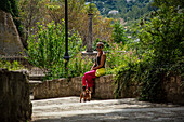  Woman with dog in an alley in Les Baux de Provence, Provence-Alpes-Côte d&#39;Azur, France 