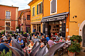 Restaurant mit Touristen in der Altstadt von Roussillon, Département Vaucluse, Provence-Alpes-Côte d’Azur, Frankreich