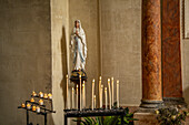 Marienfigur und Kerzen in der Kirche in der Altstadt von Roussillon, Département Vaucluse, Provence-Alpes-Côte d’Azur, Frankreich