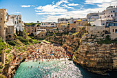  Blick auf Cala Monachile oder Lama Monachile mit der römischen Brücke hinter der Bucht Polignano a Mare, Apulien, Italien. 