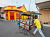  Straßenhändler schiebt seinen mobilen Imbissstand die Ketandan Wetan Straße hinauf. Yogyakarta, Java, Indonesien. 