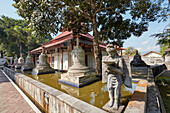 Statue und Stupas im Garten des buddhistischen Kloster Mendut. Regentschaft Magelang, Java, Indonesien.