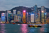  Ikonischer Blick auf die in der Abenddämmerung beleuchteten Hochhäuser der Central Waterfront. Hongkong, China. 