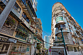 Residential buildings with fenced windows and balconies in the historic centre of Macau city, China.