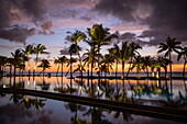 Reflection of coconut palm trees in swimming pool at Trou aux Biches Beachcomber Golf Resort & Spa (Beachcomber Resorts) at sunset, Trou aux Biches, Pamplemousses, Mauritius, Indian Ocean