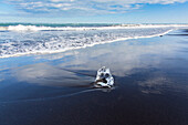 Welle und Eisbrocken am Strand Breidamerkursandur, Sudursveit, Island