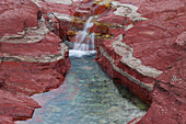  Stream flows through iron-rich rock, Red Rock Canyon, Waterton Lakes National Park, Alberta, Canada 