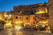 Restaurants im Sasso Barisano in der Abenddämmerung, Matera, Basilikata, Italien, Europa