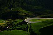 Mountain Road with View over a Mountain Valley in a Sunny Summer Day in Andermatt, Uri, Switzerland.