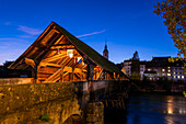 Old Town and the Historical Covered Wood Bridge Holzbrücke with Flags over River Aare in Blue Hour in Olten, canton Solothurn, Switzerland.