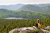 young woman admiring landscape with Pioui lake,Pioui path,Grands-Jardins National Park,Province of Quebec,Canada,North America