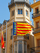 The flag of the Valencian Community and of the city of Valencia, known as Reial Senyera, waving in the wind in the Old Town of Valencia, Spain.