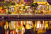 Old houses along the Thu Bon River in Hoi An Ancient Town illuminated at dusk. Hoi An, Quang Nam Province, Vietnam.