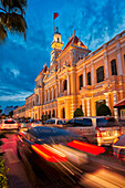 Cars pass by the People’s Committee Building in Le Thanh Ton street at dusk. District 1, Ho Chi Minh City, Vietnam.