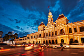  Das Gebäude des Volkskomitees ist in der Abenddämmerung beleuchtet. Bezirk 1, Ho-Chi-Minh-Stadt, Vietnam. 