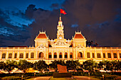  Das Gebäude des Volkskomitees ist in der Abenddämmerung beleuchtet. Bezirk 1, Ho-Chi-Minh-Stadt, Vietnam. 