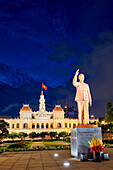  Ho-Chi-Minh-Denkmal und Gebäude des Volkskomitees in der Abenddämmerung beleuchtet. Bezirk 1, Ho-Chi-Minh-Stadt, Vietnam. 