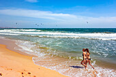 Two young women walk along the Mui Ne Beach. Mui Ne, Binh Thuan Province, Vietnam.