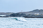 Norwegen, Finnmark, Varangerhalvøya, Berlevåg, Leuchtturm und hohe Wellen Brandung an der Küste