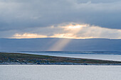 Norwegen, Magerøya, Sonnenlicht mit Sonnenstrahl an Küste