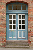  Front door old turquoise and white on brick facade 