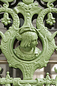  headshot of a man in an antique wrought iron entrance door 