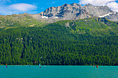 Windsurfing and Wingsurfing on Alpine Lake Silvaplana in a Sunny Summer Day with Mountain in Silvaplana, Maloja, Grisons, Switzerland.