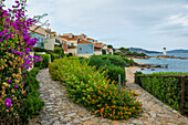 Leuchtturm mit Strand und bunten Häusern, Spiaggia Porto Faro, Faro di Punta Palau, Palau, Costa Smeralda, Sardinien, Italien