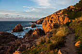  Red rocks by the sea and hiking trail, sunset, Costa Paradiso, Sardinia, Italy 