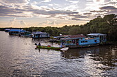  Longtail boat next to floating village on canal at Tonle Sap Lake, Chong Khnies, near Siem Reap, Siem Reap Province, Cambodia, Asia 