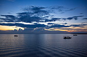  Silhouette of local tour boats on Tonle Sap Lake at dusk, Chong Khnies, near Siem Reap, Siem Reap Province, Cambodia, Asia 