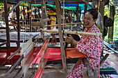  Laughing woman making silk fabric on a loom in a handicraft factory on Silk Island, Kaoh Oknha Tei, Khsach Kandal District, Kandal, Cambodia, Asia 