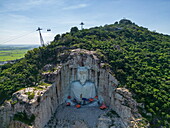  Aerial view of a giant Buddha sculpture on the mountainside (still under construction) on Mount Sam, Nui Sam, Chau Doc, An Giang, Vietnam, Asia 