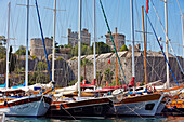 Traditional Turkish gulets moored at Bodrum Marina near the Bodrum Castle. Bodrum city, Mugla Province, Turkey.