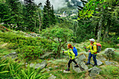  Man and woman hiking with pilgrimage church of Oropa in the background, UNESCO World Heritage Site Sacri Monti, GTA, Grande Traversée des Alpes, Biella, Alpi Biellesi, Valais Alps, Piedmont, Italy 