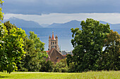 Cathedral of Notre Dame Tower and Chateau Saint-Maire roof with the Leman Lake in background seen from the gardens of the Fondation de l'Hermitage,Lausanne,Canton of Vaud,Switzerland,Europe