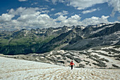  Woman descends from Magerstein over old snowfield, Magerstein, Rieserferner Group, South Tyrol, Italy  