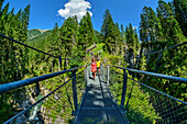 Mann und Frau beim Wandern gehen über Namloser Hängebrücke, Lechtaler Alpen, Tirol, Österreich