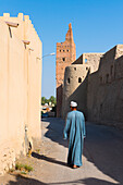 Man walking in a narrow street of Al Bilaad Historical Village at Manah, Governorate of A’Dakhiliyah, Sultanate of Oman, Arabian Peninsula, Middle East