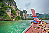 Bow of traditional Thai long-tail boat navigating Tonsai Bay near West Railay Beach. Krabi Province, Thailand.