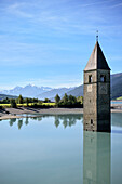 Kirchturm aus dem überfluteten Alt-Graun ragt aus dem Reschensee (Lago di Resia) am Reschenpass, Vinschgau, Südtirol, Italen, Alpen, Europa