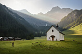 Wanderin vor Kapelle Heiliger Rochus im Nenzinger Himmel (Alpe im Gamperdonatal bei Nenzing), Panüeler Kopf im Hintergrund, Vorarlberg, Österreich, Europa