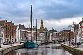  Typical canal with sailing boats and the tower of the Aa Church in Groningen, Netherlands  