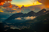 Beautiful Aerial View over Alpine Lakes and Swiss Alps and Cityscape in Sunset and Storm Clouds over St Moritz, Maloja, Grisons, Switzerland.