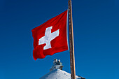 Sphinx Observatory At Top Of Jungfraujoch and Swiss Flag in a Sunny Winter Day in Canton Bern in Switzerland.