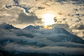 Schneebedeckter Berggipfel mit Wolkenlandschaft und Sonnenlicht in Lungern, Kanton Obwalden, Schweiz.