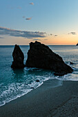 Felsen am Strand bei Dämmerung, Monterosso, Cinque Terre, Provinz La Spezia, Ligurien, Italien