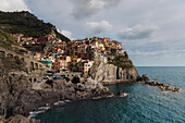 Cloudy View of buildings on rock in Manarola, Cinque Terre, Italy