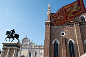 Campo Santi Giovanni e Paolo square in Venice, Italy, showing the church, flag and Equestrian Statue of Bartolomeo Colleoni