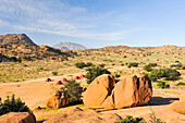 Camp in karger Berglandschaft mit Granitfelsen bei Tafraoute, Region Souss-Massa, Antiatlas, Marokko, Nordafrika